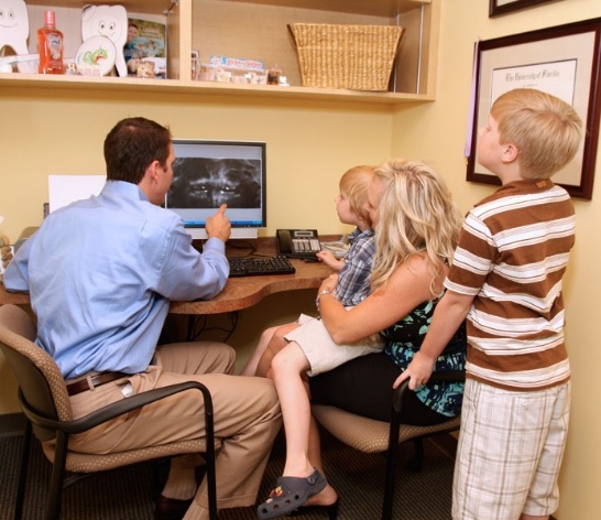 Dentist mother and children reviewing digital x-rays
