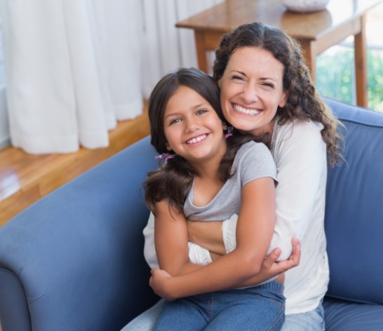 Mother and child smiling together after at home dental care