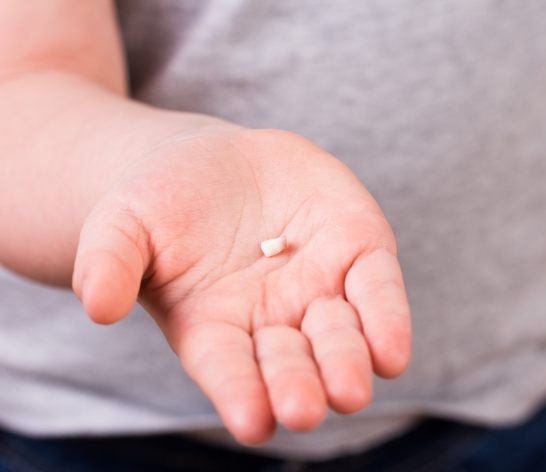 Child holding an extracted tooth