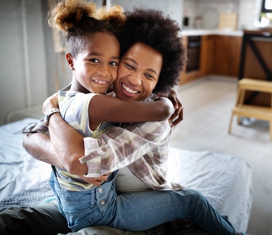 Parent hugging child after dentistry for children visit