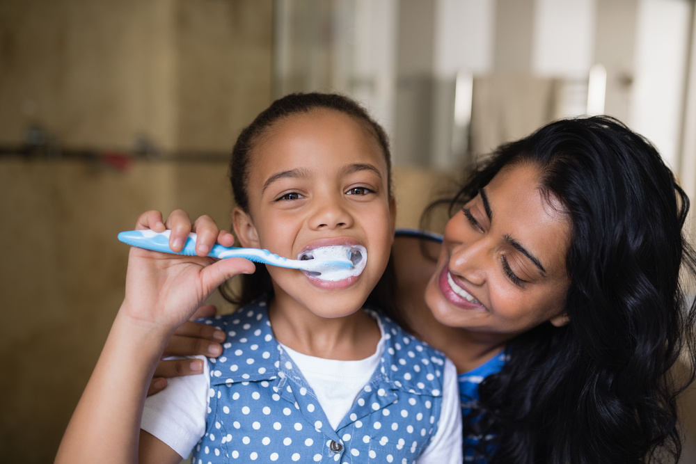 parent helping child with special needs brush teeth 