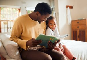 Father reading book to daughter