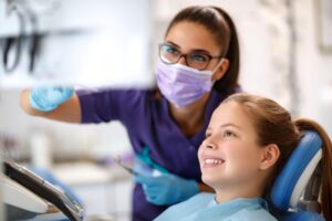 Child and dentist looking at computer monitor